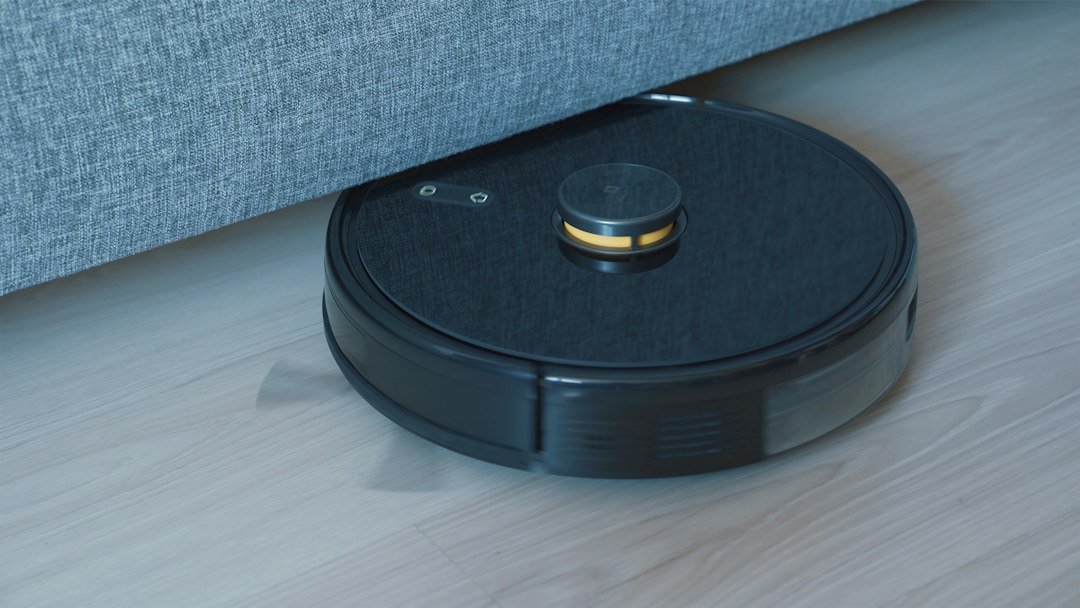 Black robot vacuum cleaner on a wooden floor